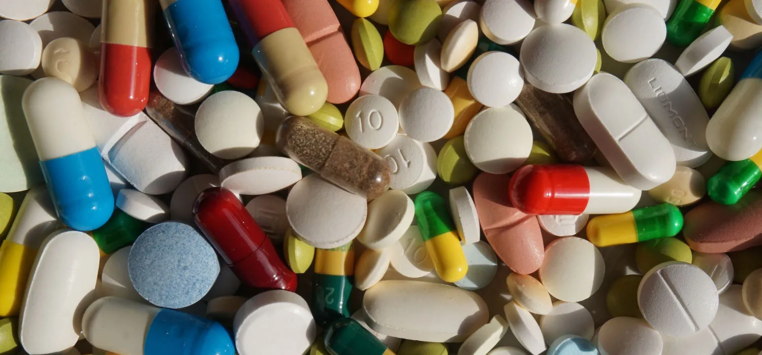 A photo shows a stack of various pills, displaying different colors.