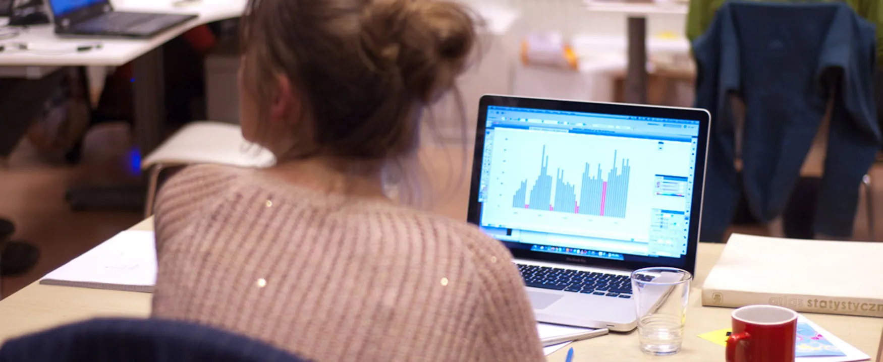 a person sits at a laptop with a chart displaying on the screen