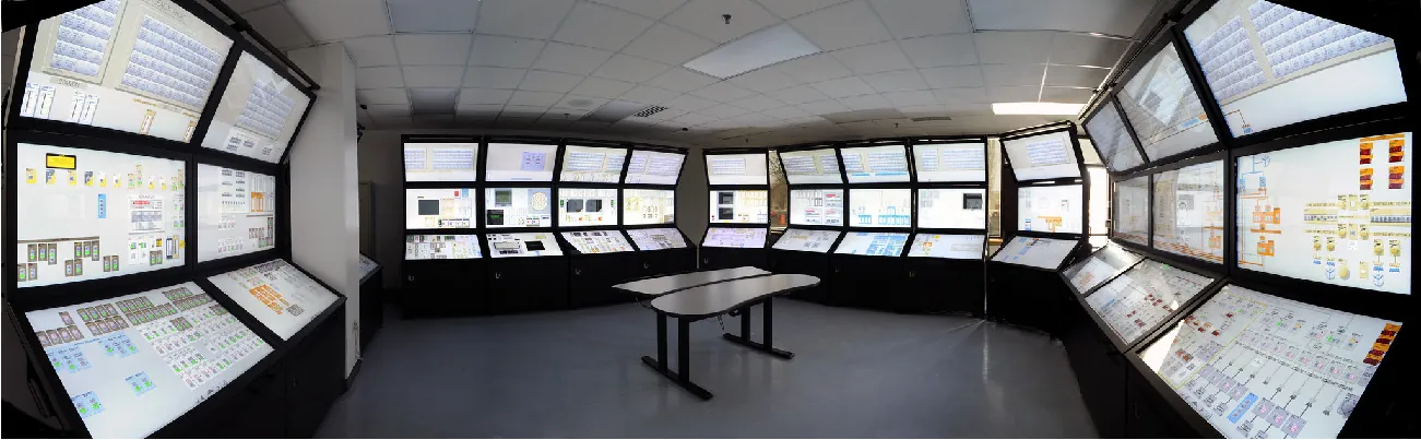 Several banks of large LCD screens display information related to the control of a nuclear power plant.