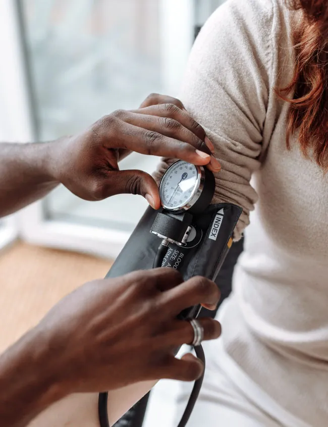 Healthcare provider checking patient's blood pressure.