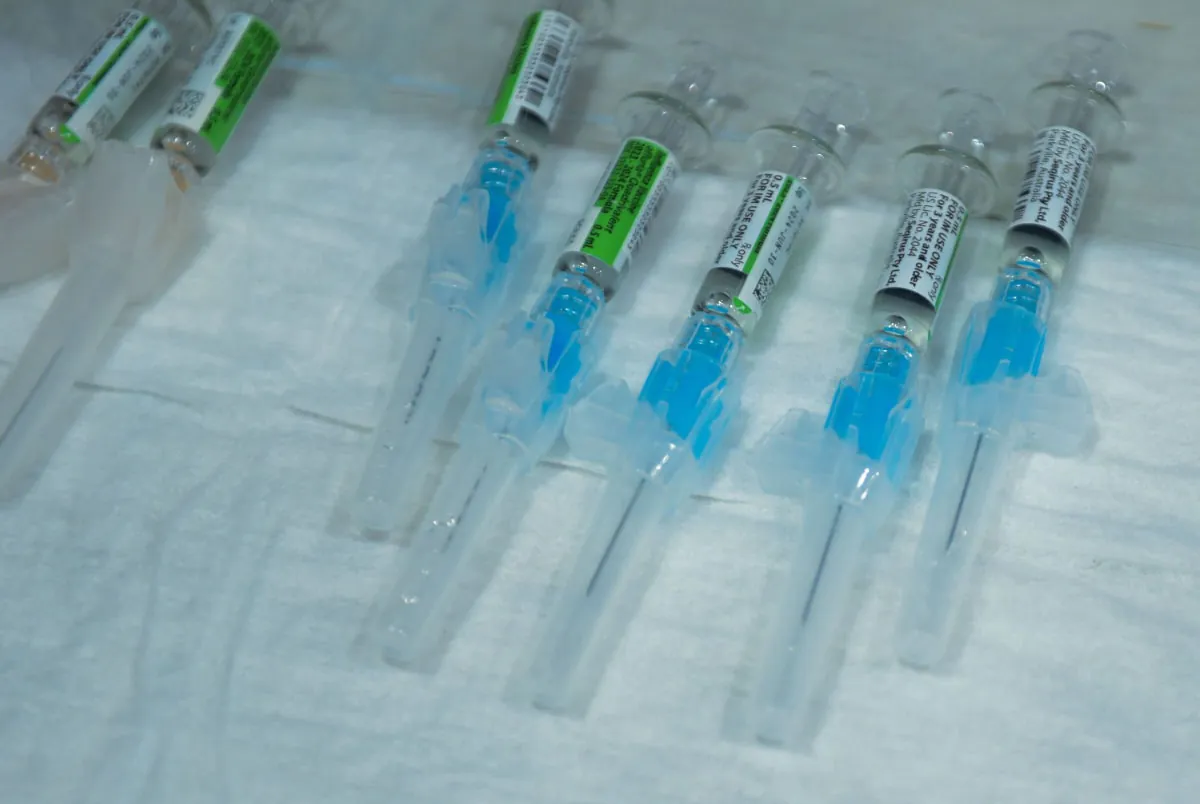 A color photograph shows several syringes with safety mechanisms.