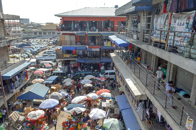 A piazza with many merchant stalls covered with umbrellas.