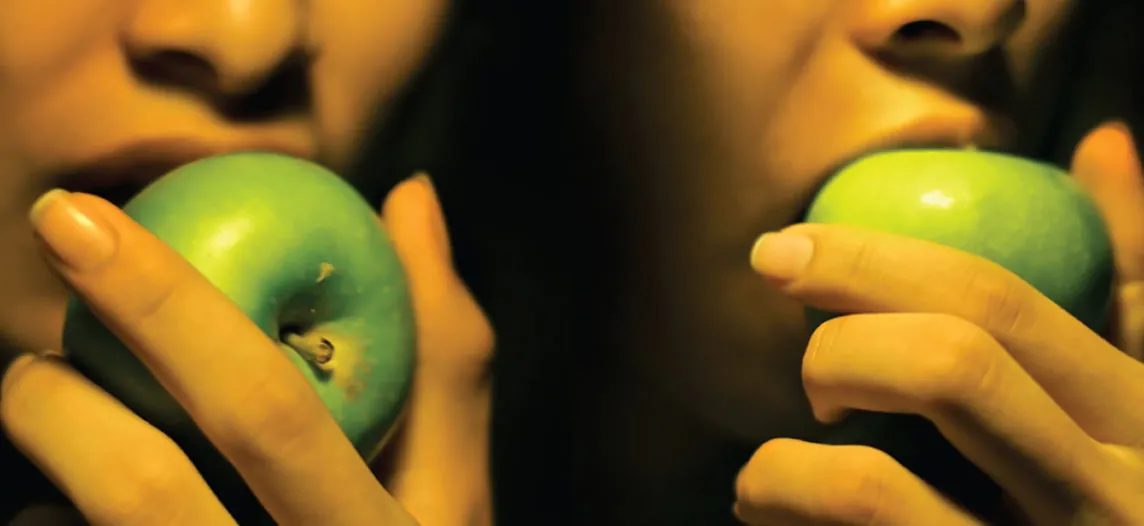 This photograph shows two women eating apples.