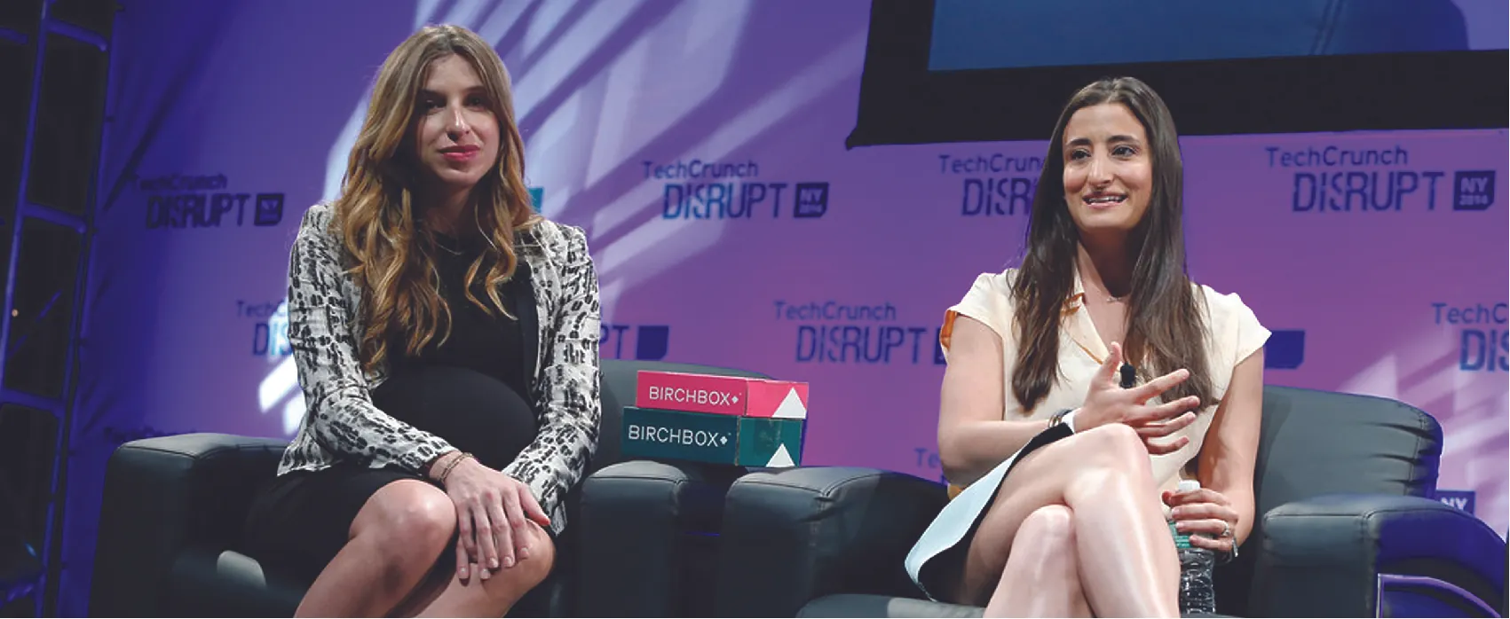 Katia Beauchamp and Hayley Barna sitting on a stage.