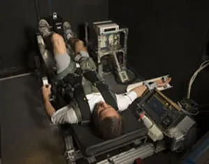 An astronaut is strapped into a G-Force simulator.
