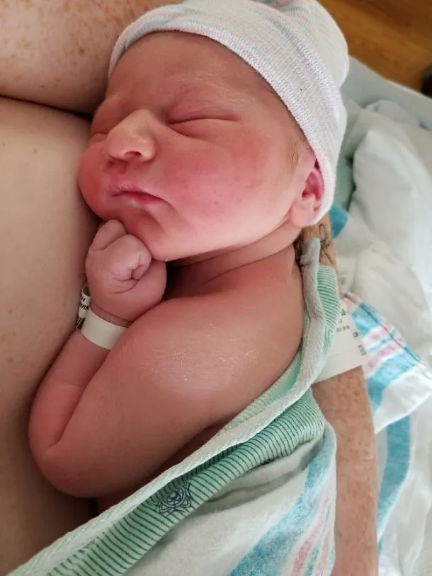 Photo of newborn lying skin on skin with a person.