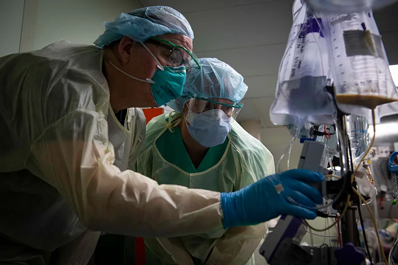 During the Covid-19 pandemic in New York City, two medical professionals work together using medical equipment to analyze  patient reports, aboard the Navy hospital ship USNS Comfort.