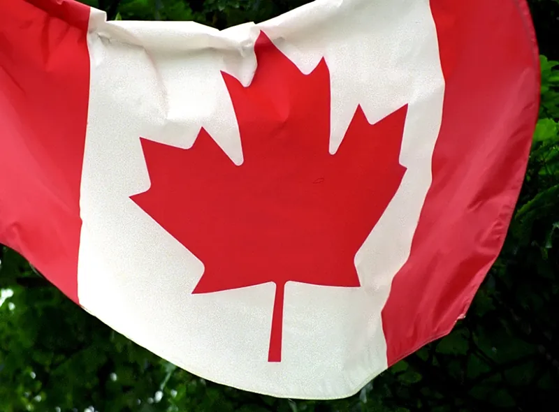 The Canadian flag has a red maple leaf in the center on a white background. Two red stripes are on the sides of the maple leaf.