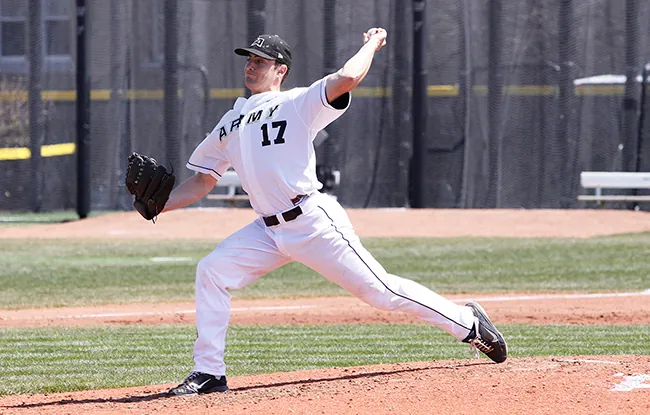 A photo shows a male baseball pitcher stretching powerfully while preparing to make a delivery.