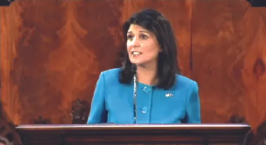 An image of Nikki Haley standing behind a podium.