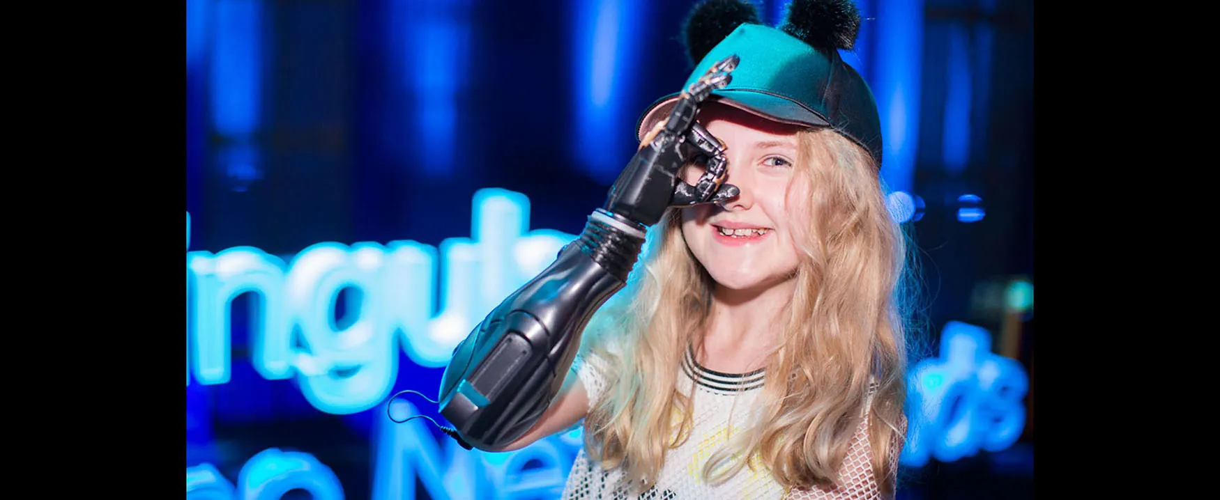 Photo of young girl with a robotic arm.