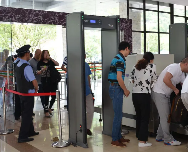 Photograph of people around a security gate at an airport departure terminal.