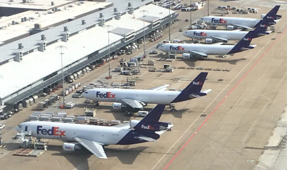 Several FedEx cargo planes parked at an airport loading area.