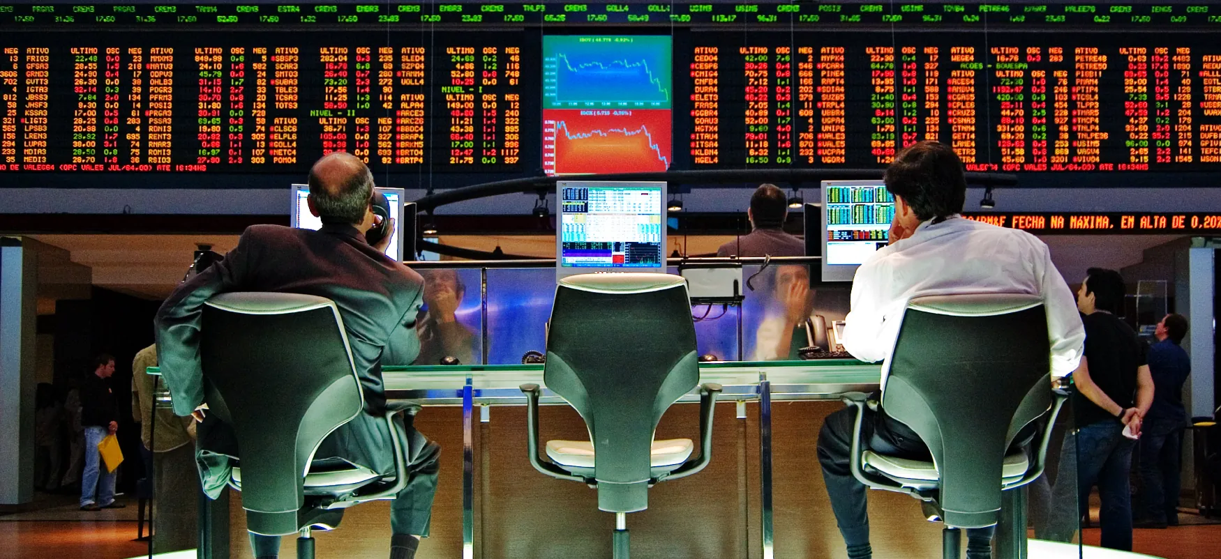 Traders review screen displays with stock market data.