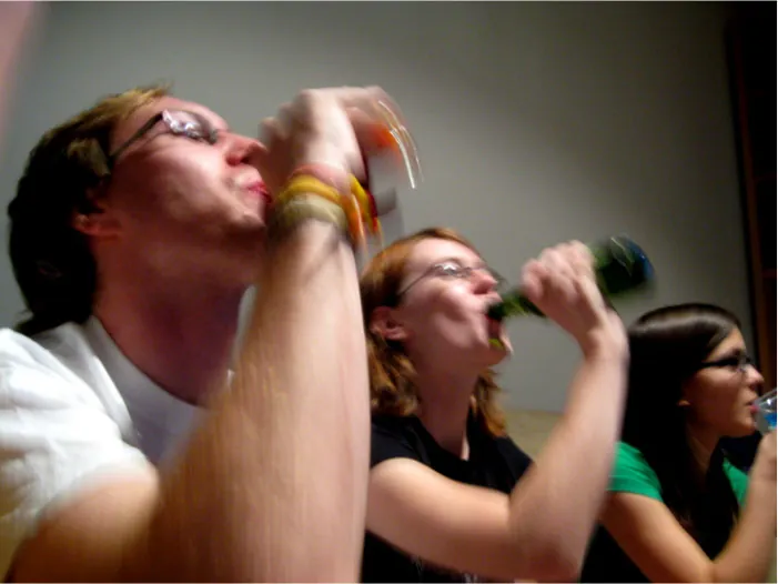 Photo of individuals drinking from glass bottles.