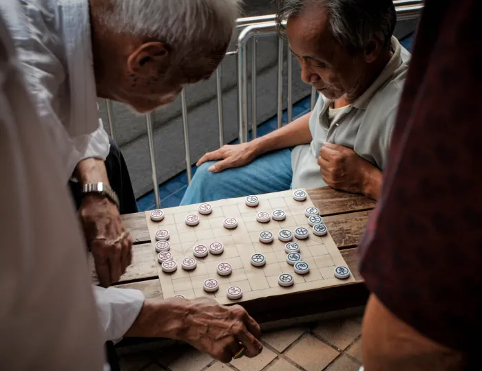 A group gathers around a board game.