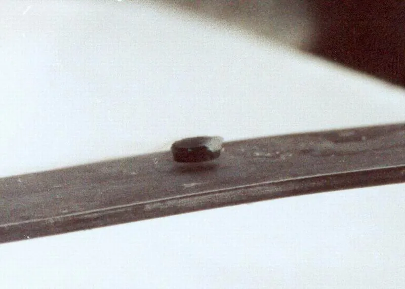 The figure shows a button-shaped magnet floating above a superconducting puck. Some wispy fog is flowing from the puck.