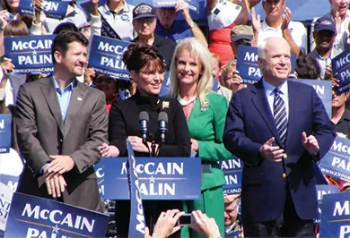 A photograph shows John and Cindy McCain and Sarah and Todd Palin standing at a lectern, surrounded by supporters holding “McCain / Palin” signs.