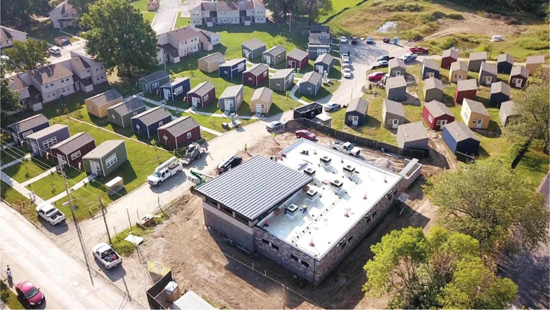 Photograph shows a community of a few dozen tiny homes.
