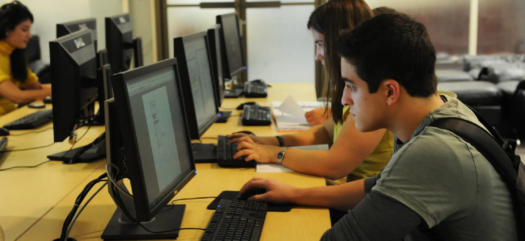 Four college students work on computers.