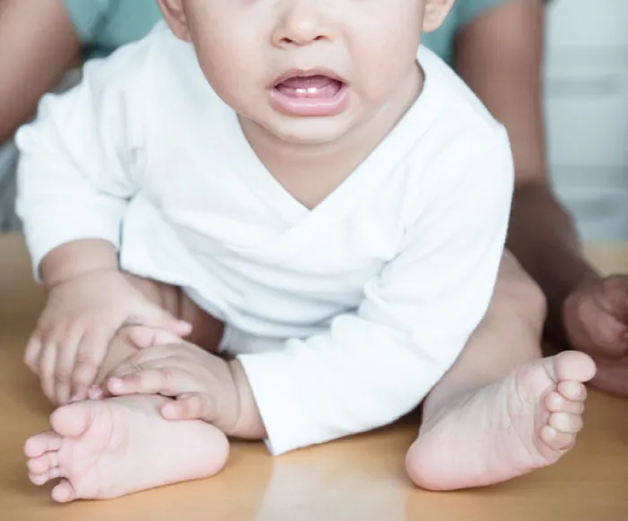 Infant showing two small front, bottom teeth.