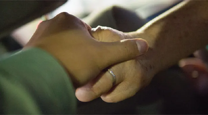 Photo two individual’s hands.