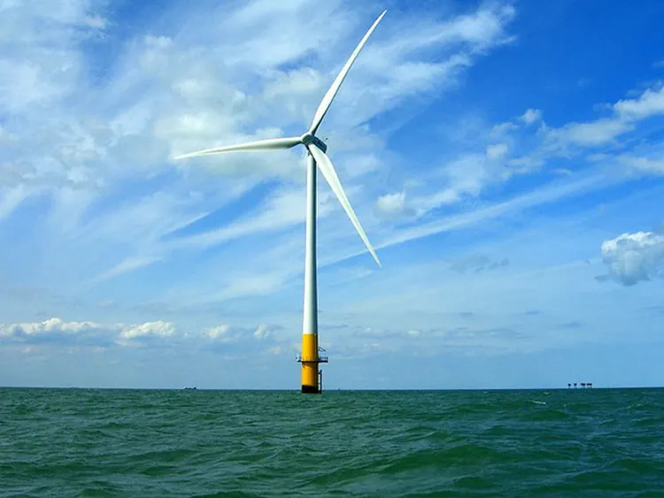 Wind turbine with three blades moored in shallow water.