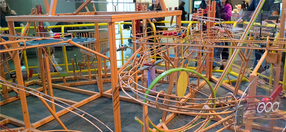 Zdjęcie toru kulkowego zawierającego złożony zestaw ścieżek, po których poruszają się kulki.