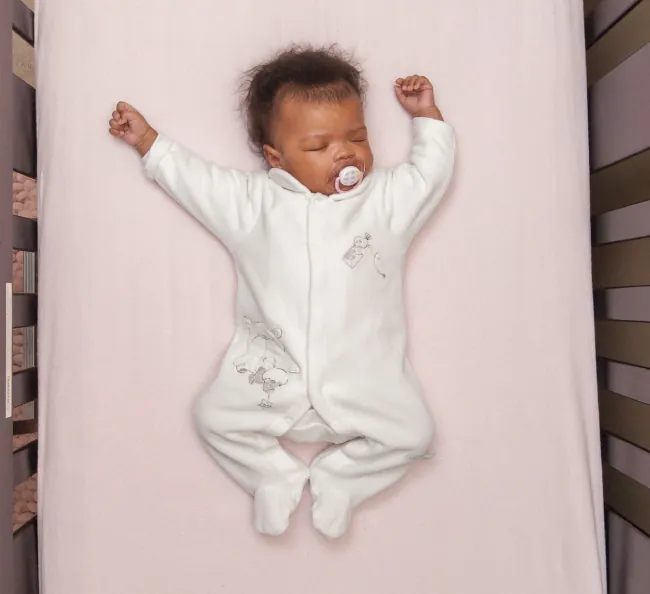 Photo of infant lying flat on their back.
