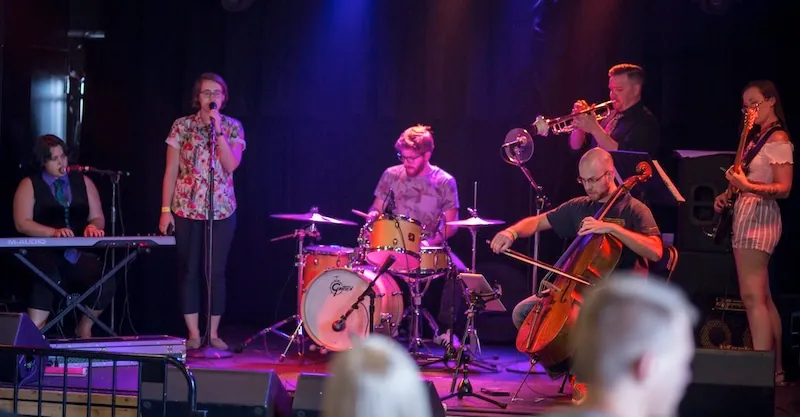 Photograph of a musical band with a person singing.