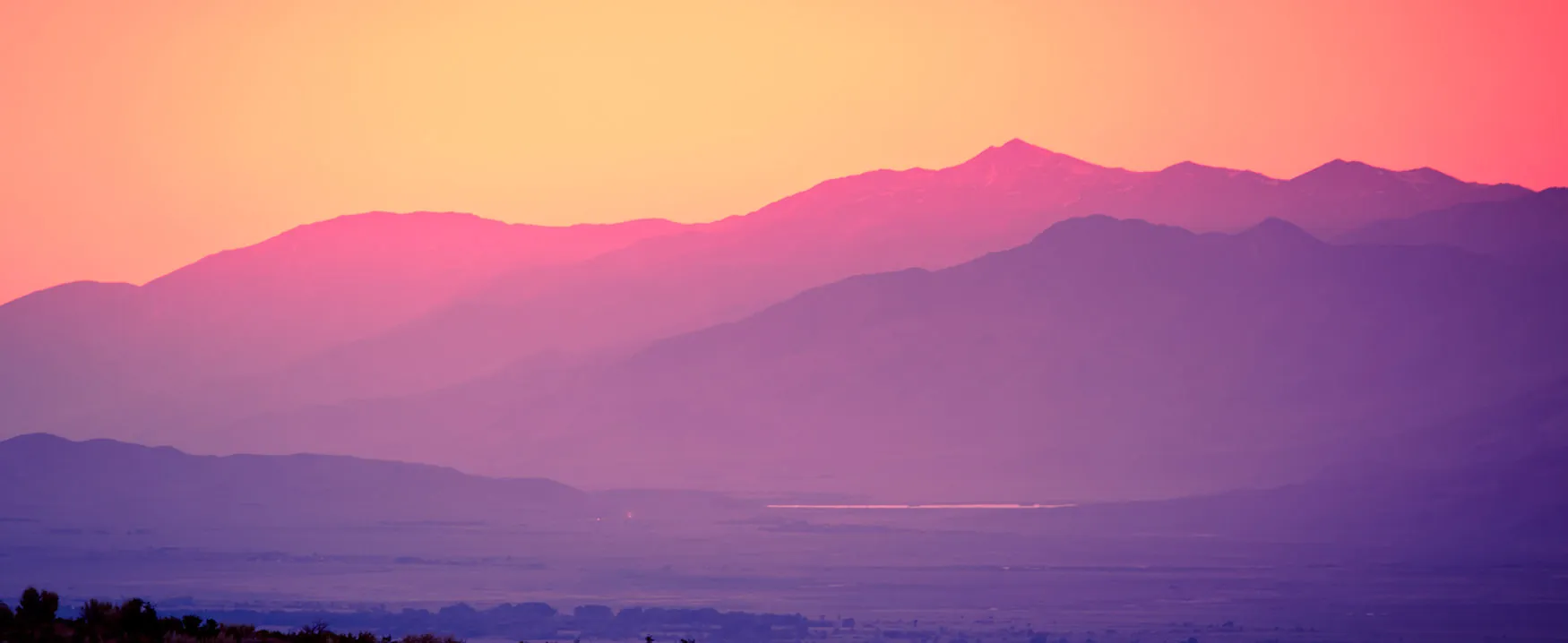 Landscape photograph of mountains with colors ranging from orange to pink to purple