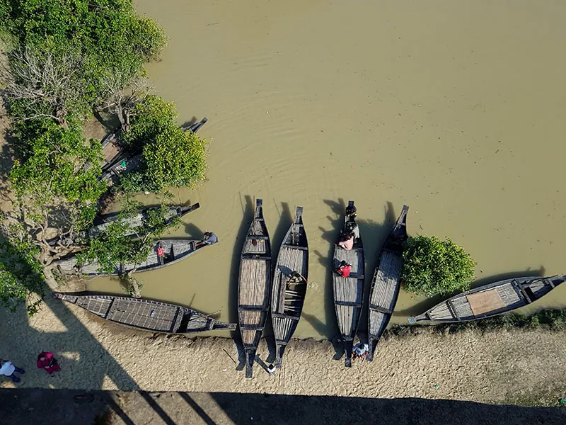 Boats carry tourists in Ratargul Swamp Forest, located in Bangladesh with boats carrying tourists. The image has repeating vertical and horizontal lines, gradient color patterns, and a red spot in the center.