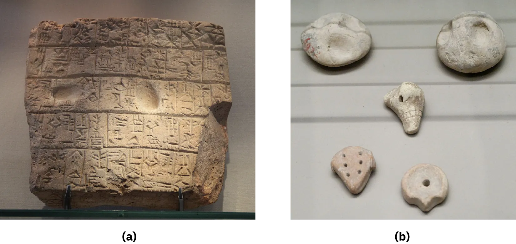 A picture of a thick, brown, square piece of clay is shown. It is irregularly shaped and broken off on the bottom right corner. Five rows of etchings are visible on the front of the piece, separated by a thick groove. Two oval indentations are shown in the third row. The piece sits on a wire stand against a gray wall.