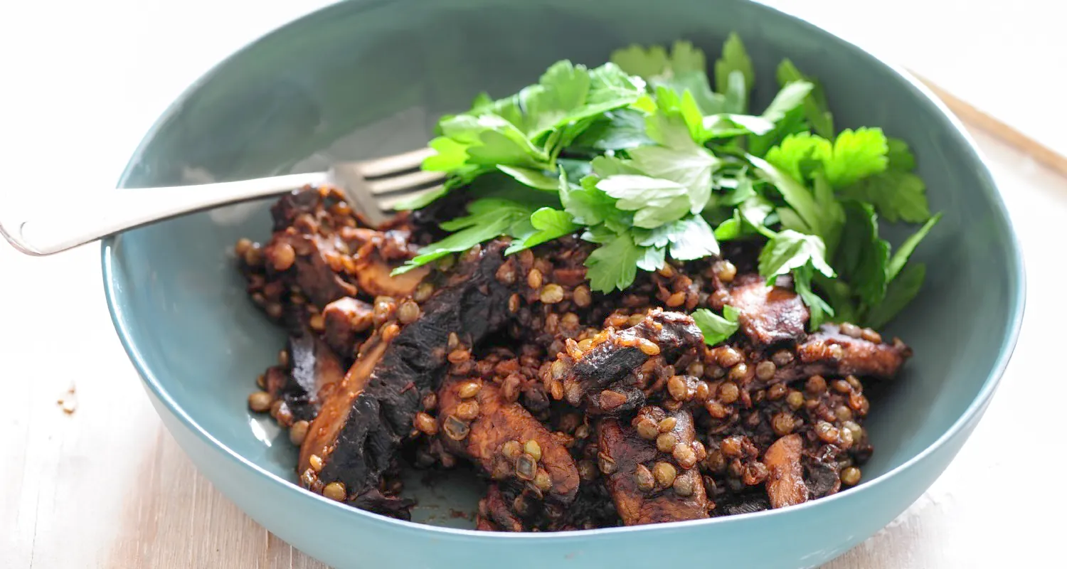 Raw salmon cut into small squares, with lemon slices and small green leaves for garnish.