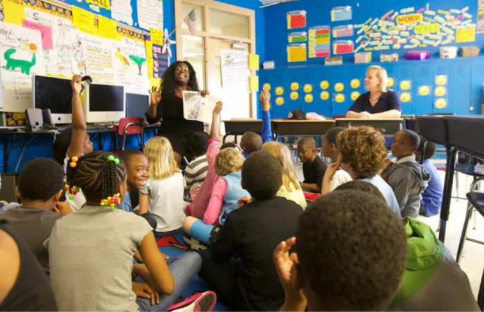Students and teachers interact in a classroom.