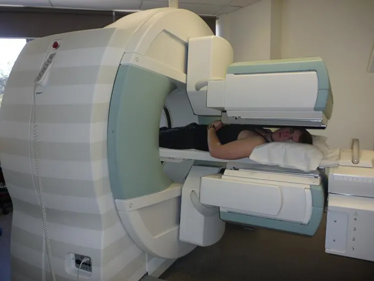 A man lying down, going through a cylindrical scanning machine.
