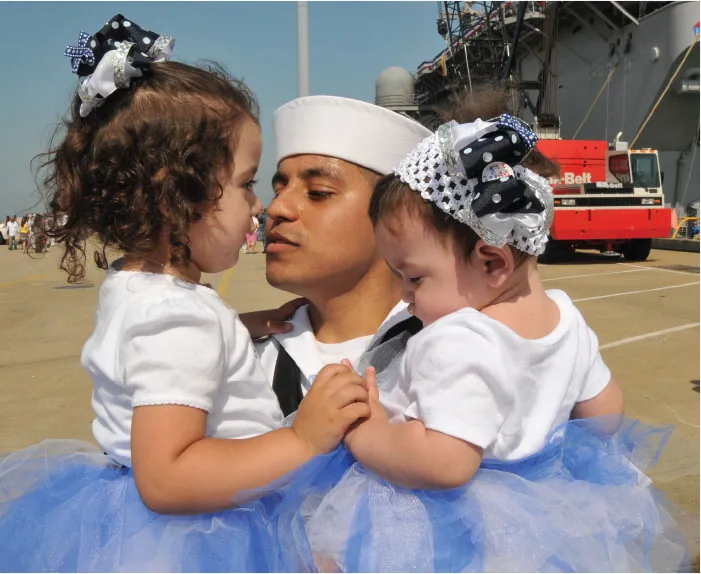 A parent holds two young children.