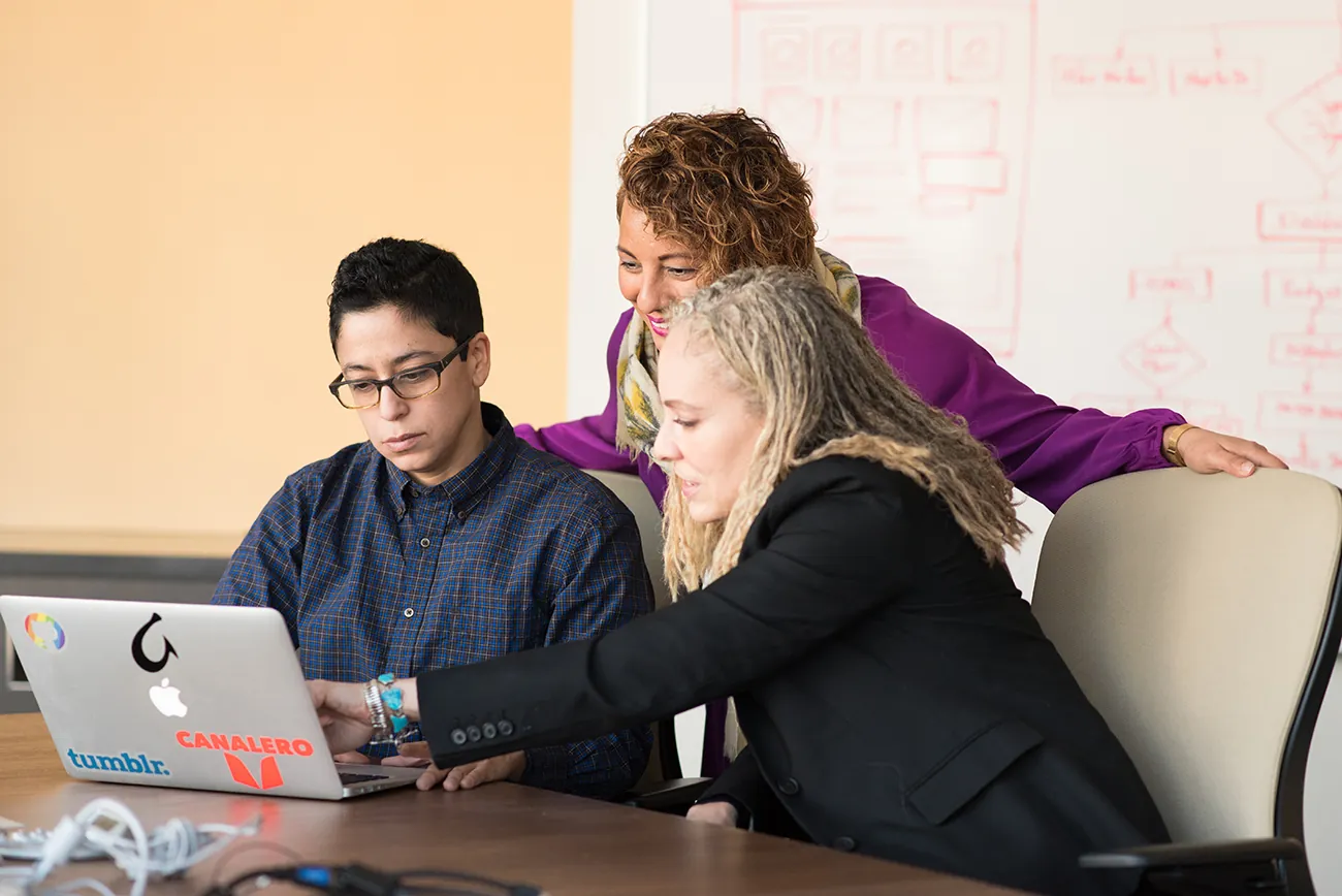 A photo shows a diverse team of business professionals working together on a laptop.