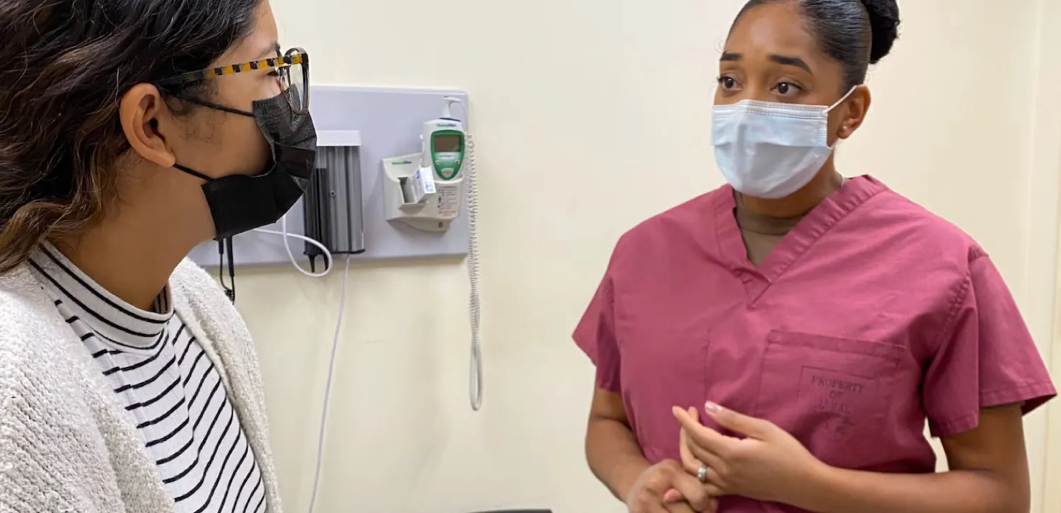 Image of nurse speaking with patient in doctor’s office.