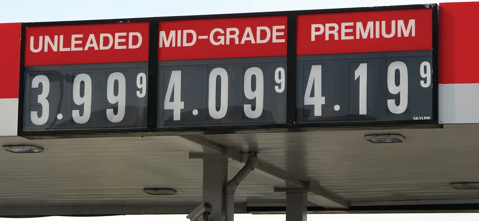 A gas station sign is shown. It lists unleaded as 3.999, mid-grade as 4.099, and premium as 4.199.