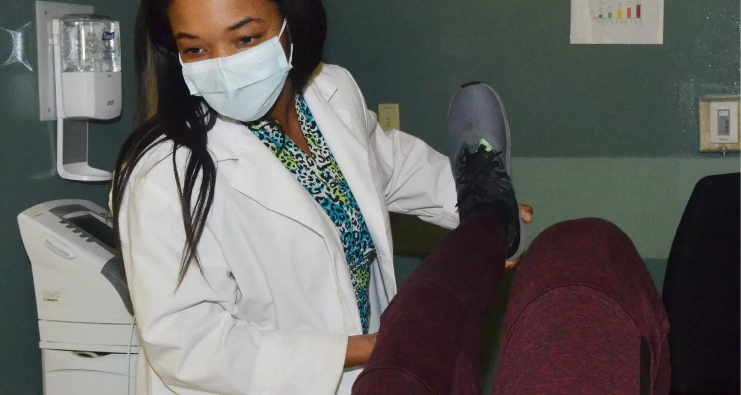 A doctor tests a patient’s leg mobility.