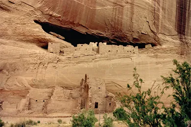 A photograph of Anasazi cliff dwellings shows blocky adobe structures with window and door openings, some of which are set atop a high, sheer cliff.