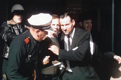 A photograph shows several men arresting Lee Harvey Oswald.