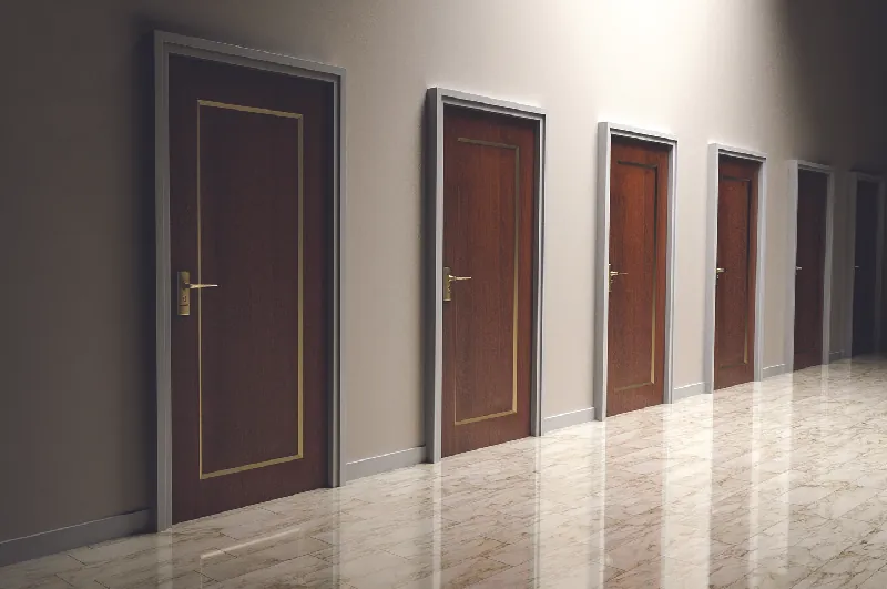 This image shows a row of six doors along the wall of an empty room.