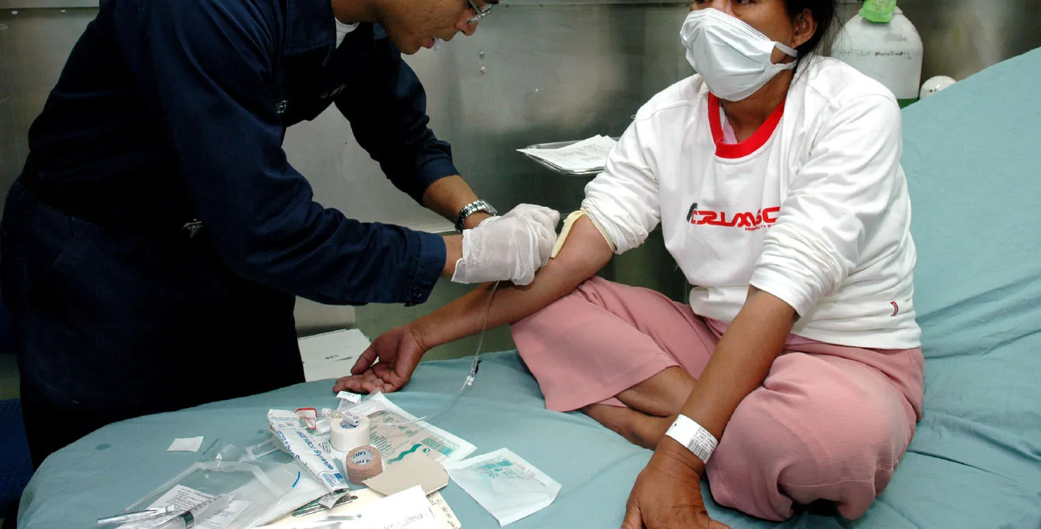 A color photograph shows a medical professional preparing a patient for an IV.