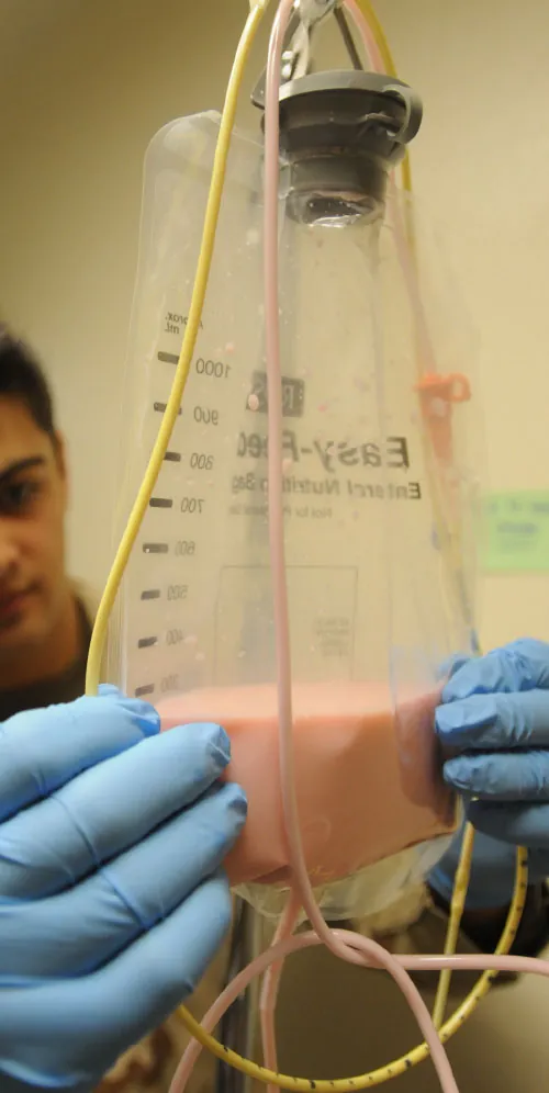 A nurse administering a feeding tube.