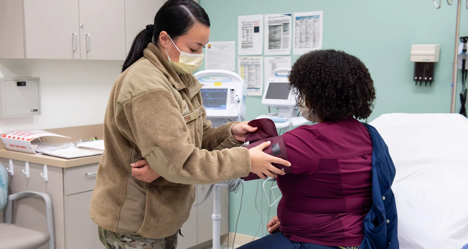 A photograph of a nurse examining a patient’s arm.
