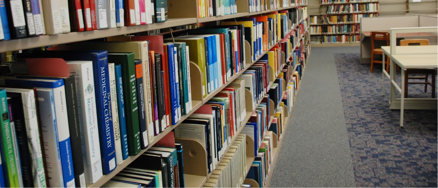 A photo of a bookshelf full of pharmaceutical and medicinal chemistry books in the Kent State University Chemistry Physics Library.