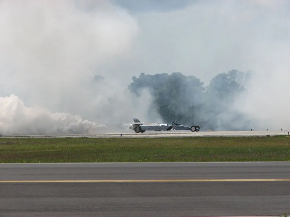 A photo shows a U S Air Force jet speeding down a track with a lot of smoke around it.