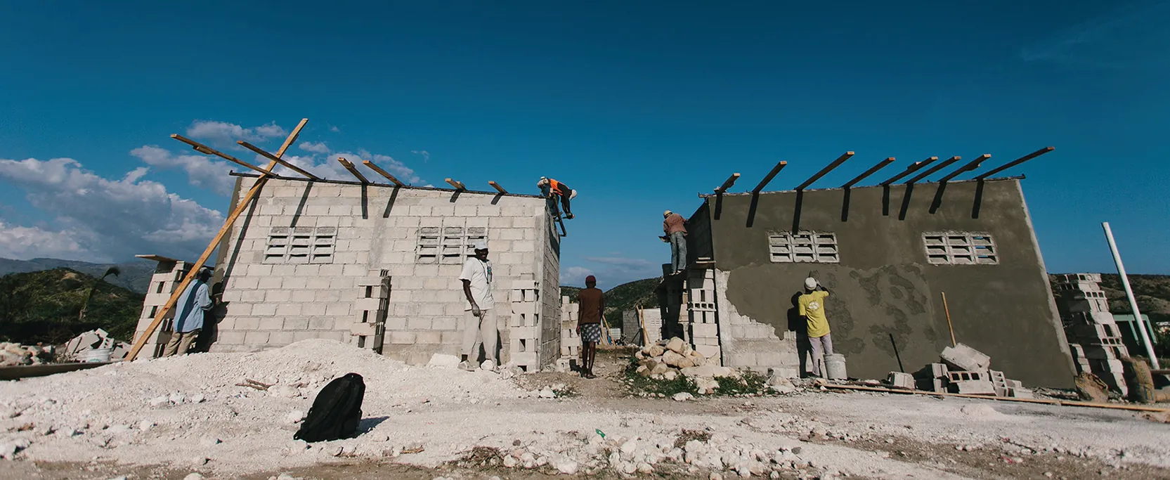A photograph shows people building houses in Haiti.